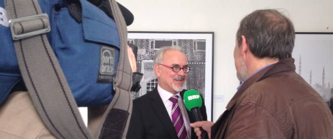 Städteregionsrat Helmut Etschenberg wird von belgischen Journalisten zur Ausstellung befragt. 
